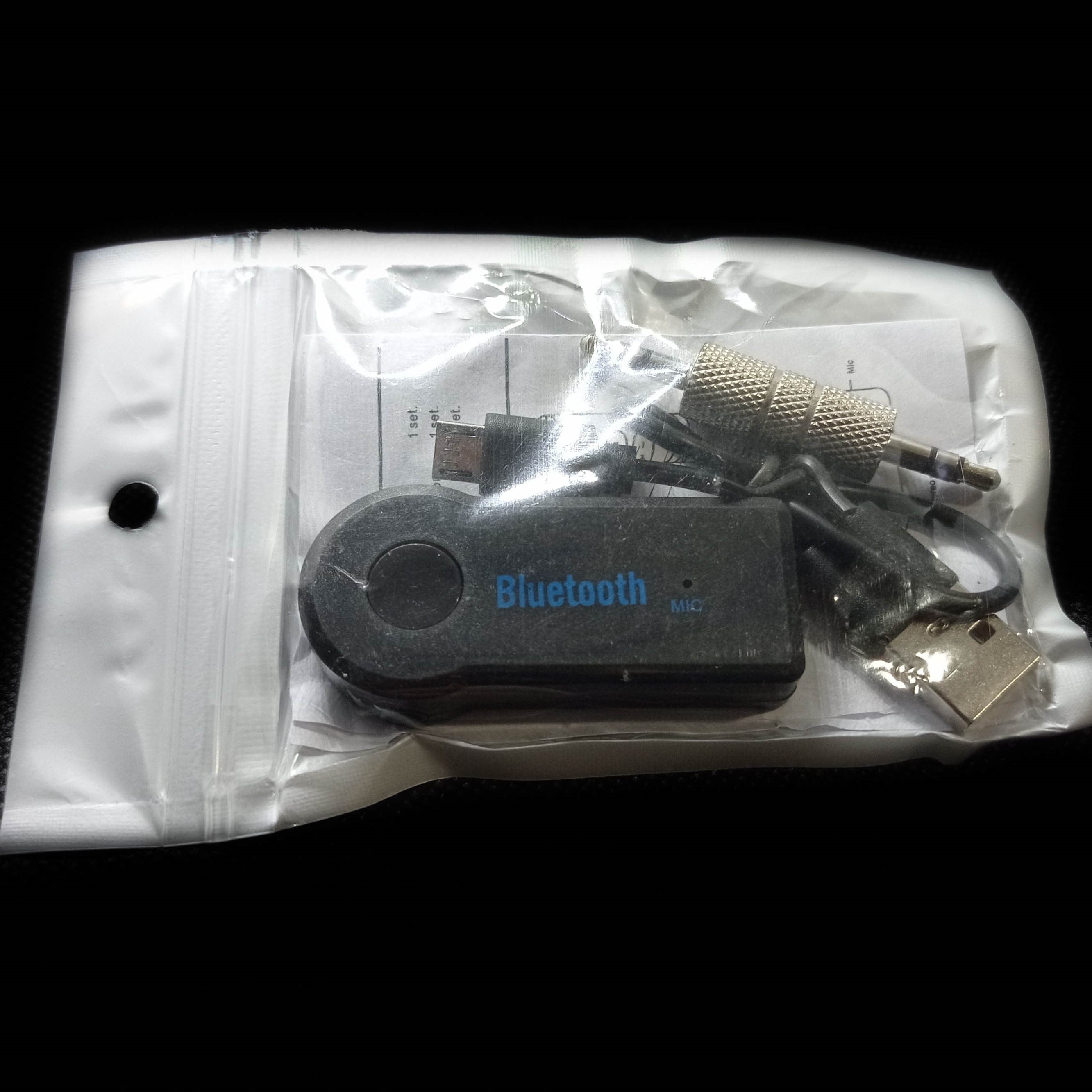 Transmissor Bluetooth AUX dentro da sua caixa, com o produto principal, cabos de ligação e manual de instruções